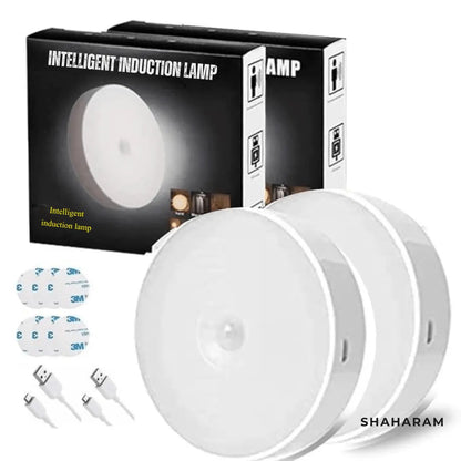 Pack of 2 smart motion sensor night lights with product boxes, USB charging cables, and adhesive sticky pads.